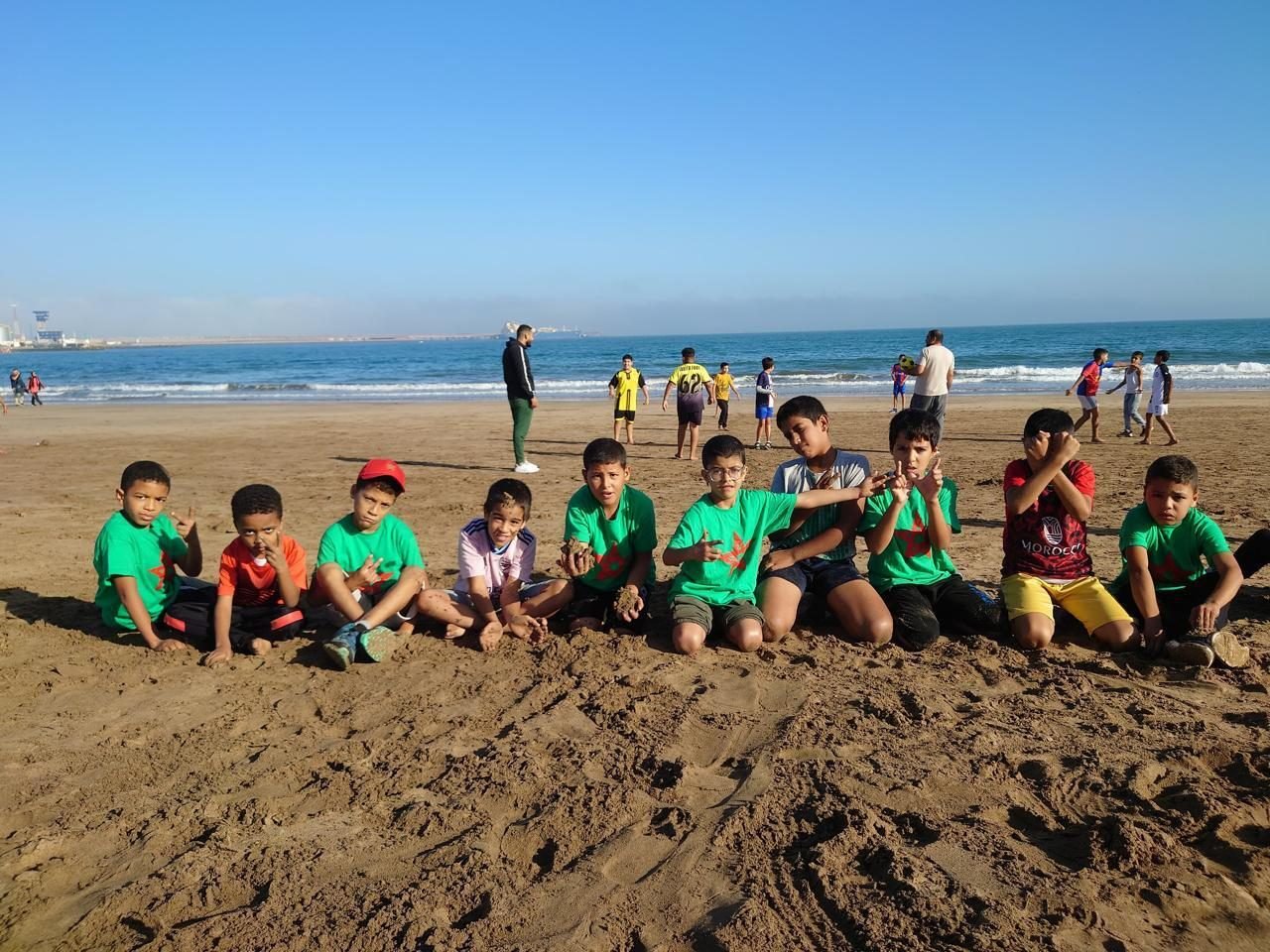 Des enfants assis sur la plage pendant une sortie